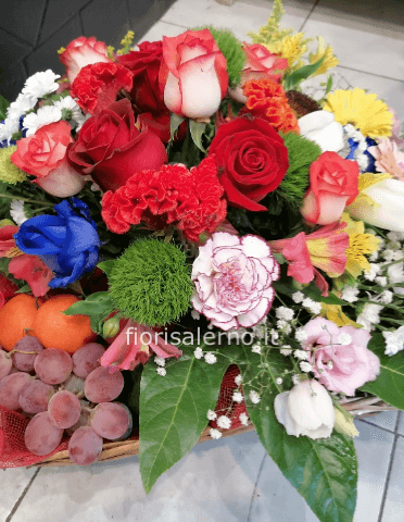 Cesto di vimini con fiori e frutta di stagione